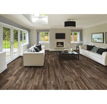 Ljust vardagsrum med brunt trägolv, vita soffor och öppen spis.