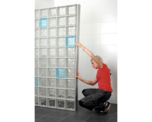 Kvinna installerar glasblockvägg i badrummet med några färgade accenter.