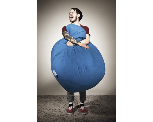 Man somfamnar en blå sittsäck inomhus