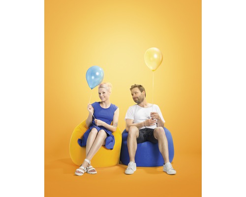 En man och en kvinna sitter på sittsäckar med ballonger.