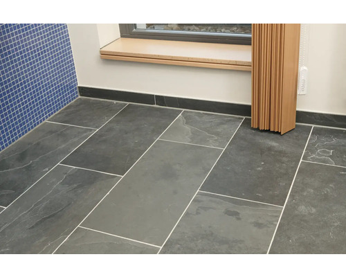 Badrum med golvkakel och blå väggkakel.