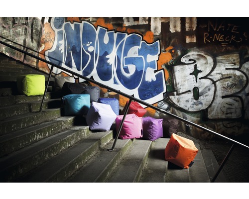 Flera sittkuber på trappor framför en vägg med graffiti