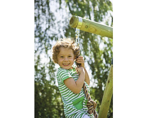 Ett barn klättrar på ett rep på en lekplats.