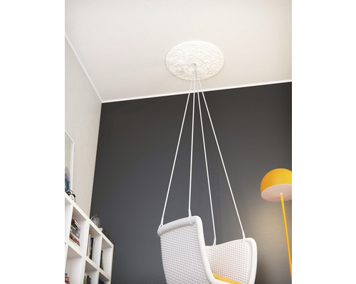 Takrosett med dekorativa ornament och hängande stol fäst i taket.