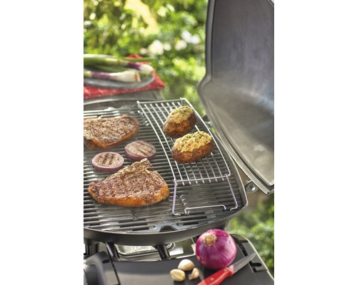 Grillscen med biffar, lök och fyllda potatisar på en grill