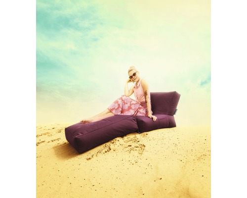 Kvinna sitter på en lila sittsäck utomhus