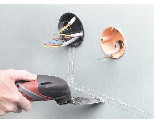Oscillerande elverktyg som används för att skära gipsskivor bredvid elinstallationsdosor