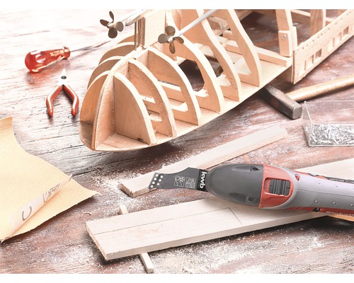 Träfartygsmodell under konstruktion med multiverktyg, hammare och skruvmejsel