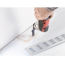 Scen med hantverkare som skär ett spår med ett multifunktionellt verktyg för ett ventilationsgaller