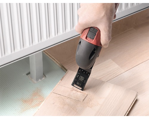 Multifunktionsverktyg som används för att skära ett trägolv nära ett element