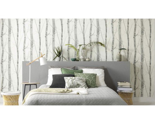 Sovrum med säng framför en vägg med björkskogstapet