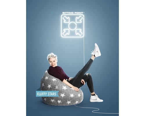 Kvinna sitter i en grå sittsäck med stjärnmönster under en ''Sitting Point''-logotyp