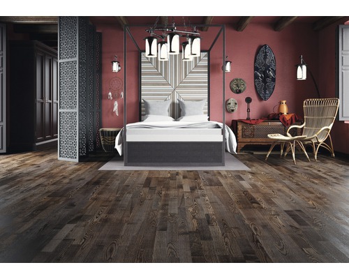 Sovrum med himmelssäng, trägolv och dekorativa element i etnisk stil