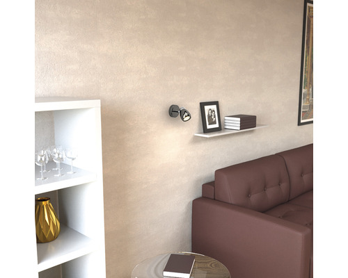 Vardagsrum med brun soffa, hylla, dekoration och vägglampa