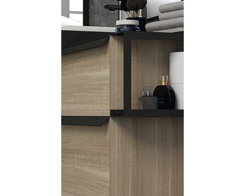 Detaljbild av ett badrumsskåp med trädekor och svarta detaljer, inklusive förvaringsutrymme för badrumsartiklar