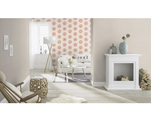 Vardagsrum med soffa, lampa, öppen spis och mönstrad tapet