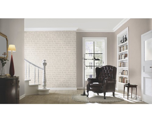 Vardagsrum med fåtölj, golvlampa och dekorativ väggtapet