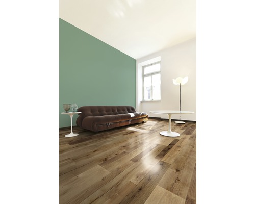 Vardagsrum med trägolv, soffa, bord och golvlampa