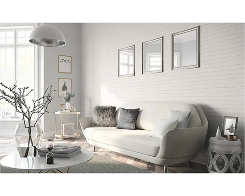 Vardagsrum med soffa, soffbord och dekorativa tillbehör framför en tegelvägg