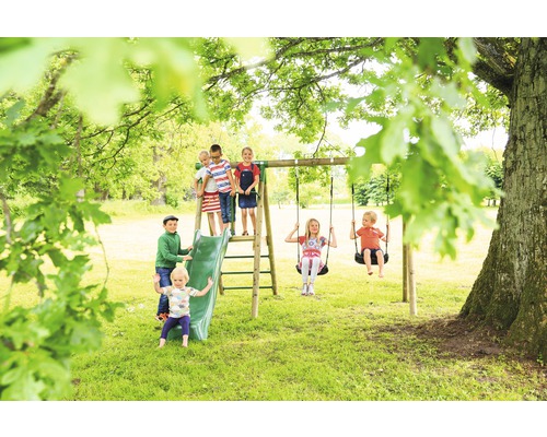 Barn leker på en lekplats med gunga och rutschkana utomhus.