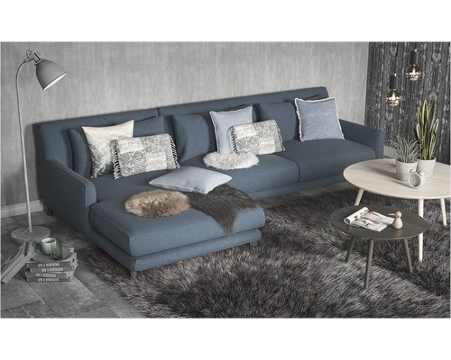 Vardagsrum med hörnsoffa, kuddar, matta och soffbord