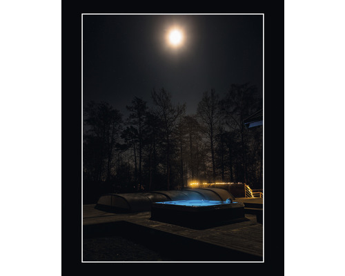 Utespa med person i vatten på natten under månen