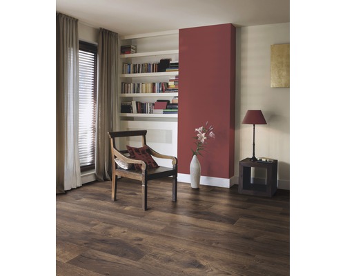 Vardagsrum med laminatgolv i träutseende, fåtölj och bokhylla