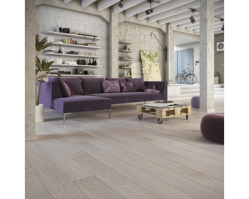 Vardagsrum med trägolv, soffa och hyllor