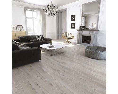 Ljust vardagsrum med soffa, bord, fåtölj, öppen spis och trägolv