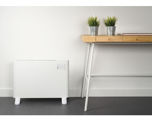 Vit radiator bredvid skrivbord med dekoration