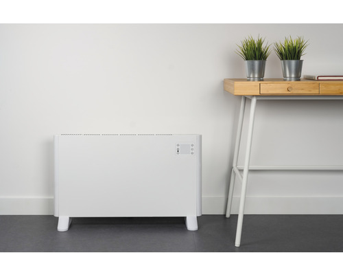 Elektrisk konvektionsvärmare bredvid ett skrivbord