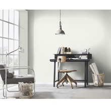 Ljust arbetsrum med skrivbord, stol, lampa och dekoration