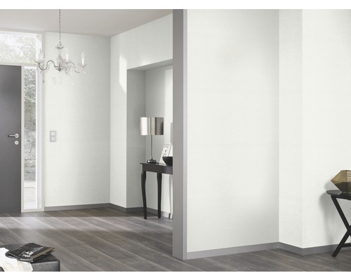 Ljust rum med dörr, ljuskrona och trägolv.