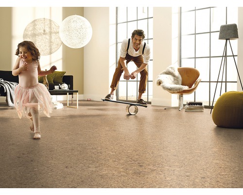 Vardagsrum med korkgolv, lekande flicka och man på balansbräda