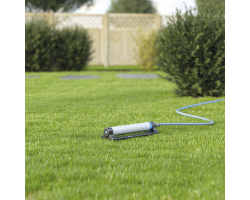 Grässpridare på gräsmatta med slanganslutning