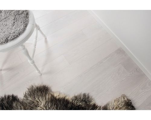 Ljust rum med trägolv, stol och matta