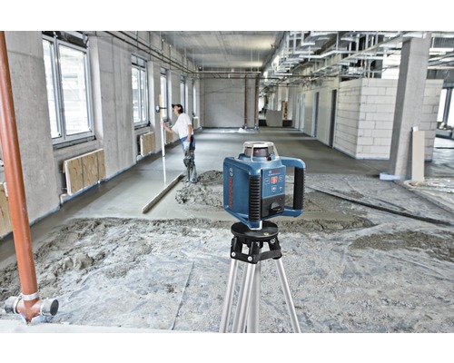 Bosch logotyp. Byggarbetsplats med roterande laser på stativ för utjämning av avjämningsmassa.