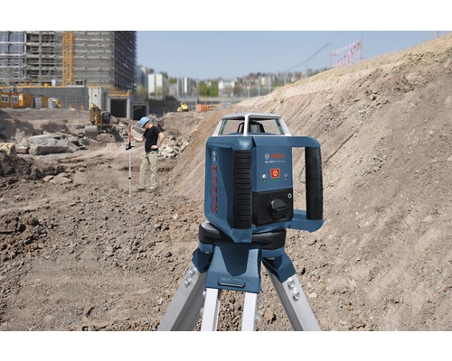 Byggarbetsplatsscen med en roterande Bosch-laser på ett stativ för horisontell utjämning