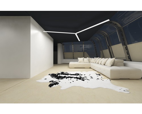 Ljust vardagsrum med hörnsoffa, matta i kohudlook och taklampa