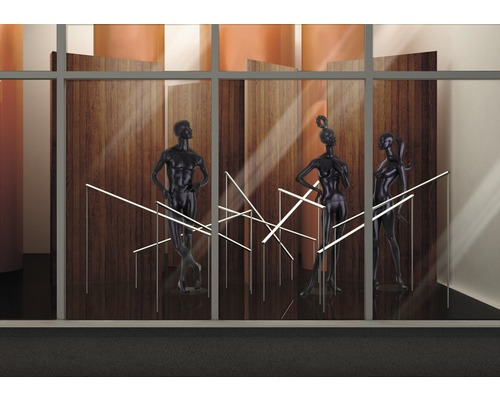 Fönsterdekoration med tre skyltdockor och LED-lampor framför en trävägg