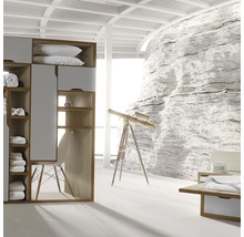 Ljust sovrum med garderob, fåtölj, teleskop och stenväggsdekoration