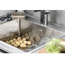 Rostfri diskho fylld med potatis, armatur och köksredskap.