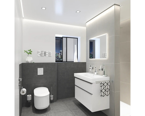 Modernt badrum med toalett, tvättställsskåp, spegel och digital klocka