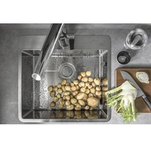 Rostfri diskho med kran, potatis och matlagningsingredienser