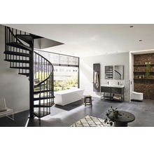 Badrum med spiraltrappa, fristående badkar, tvättställ, element och toalett.