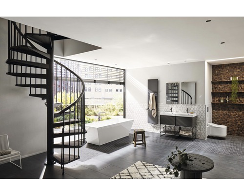 Badrum med spiraltrappa, fristående badkar, tvättställ, element och toalett.