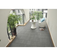 Balkong med mörka terrassplattor, sittgrupp och växt