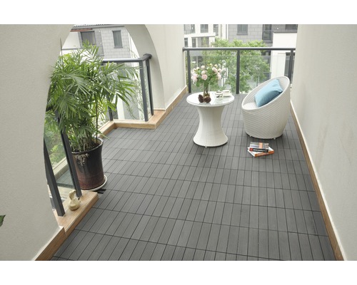 Balkong med mörka terrassplattor, sittgrupp och växt