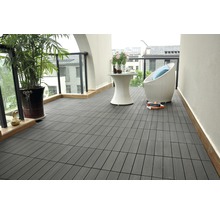 Terrass med gråa trädgårdsplattor, bord och stol