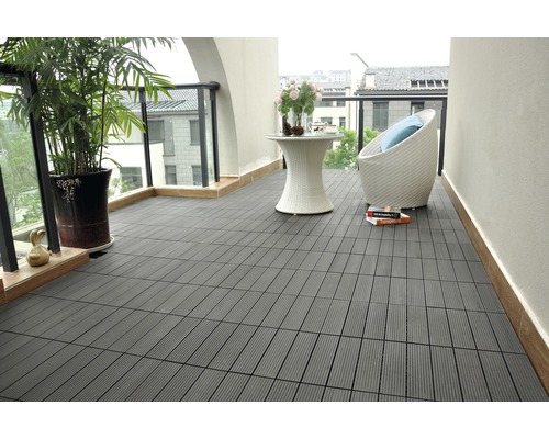 Terrass med gråa trädgårdsplattor, bord och stol